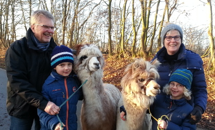 Großeltern und Enklekinder bei einem Alpaka-Spaziergang